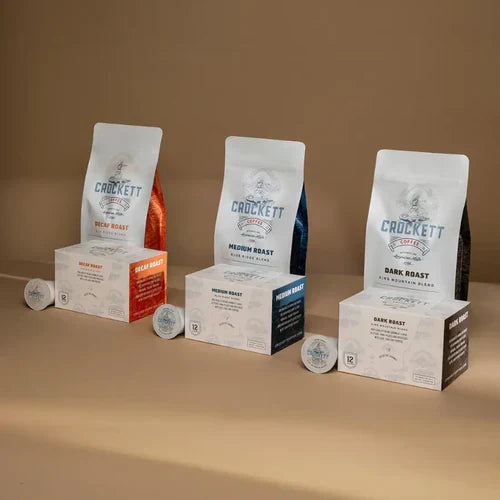 Dark roast coffee bags and K-cup boxes from Crockett Coffee displayed alongside decaf and medium roast options.