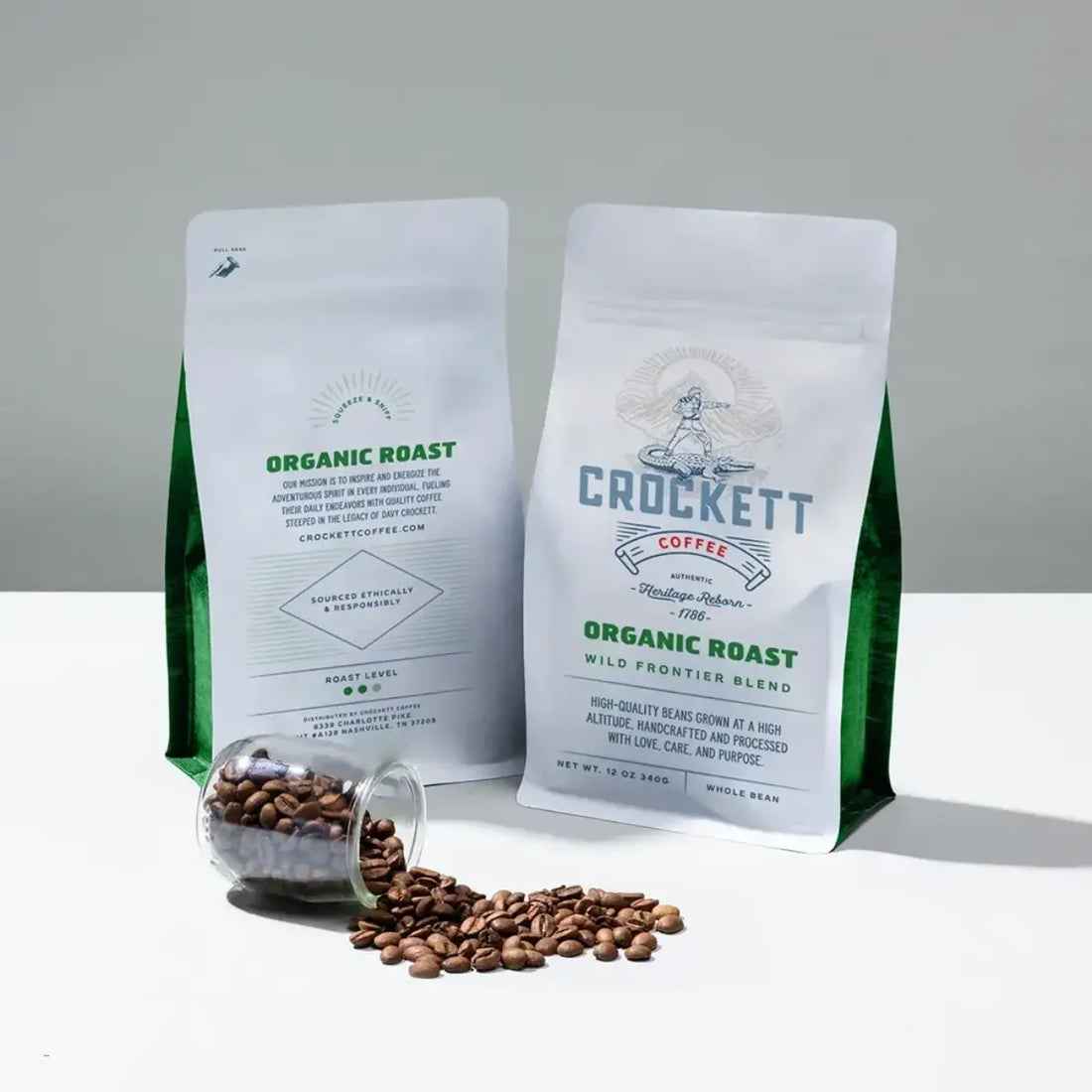 Non-toxic coffee featuring organic roast whole beans in sustainable packaging with scattered beans and a glass jar on a white surface