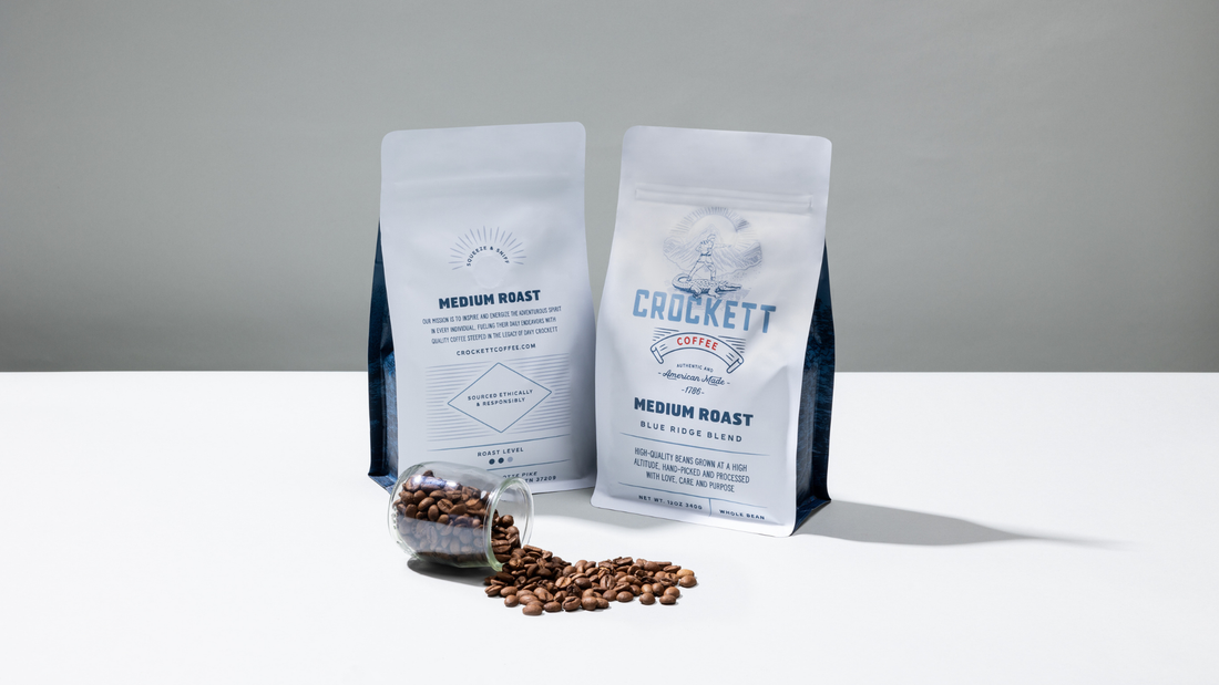 Two bags of Crockett medium roast coffee with beans in front.