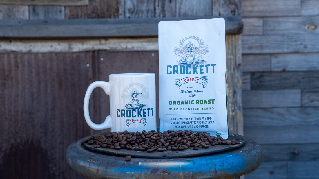 Crockett Coffee mug and bag of Organic Roast whole beans on a stool with coffee beans.