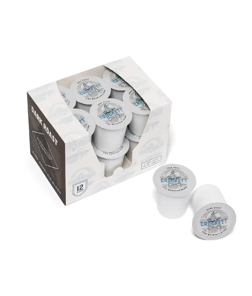 Dark roast coffee K-Cups labeled “Crockett Coffee King Mountain Blend,” with a box of 12 pods and two pods displayed outside the packaging.