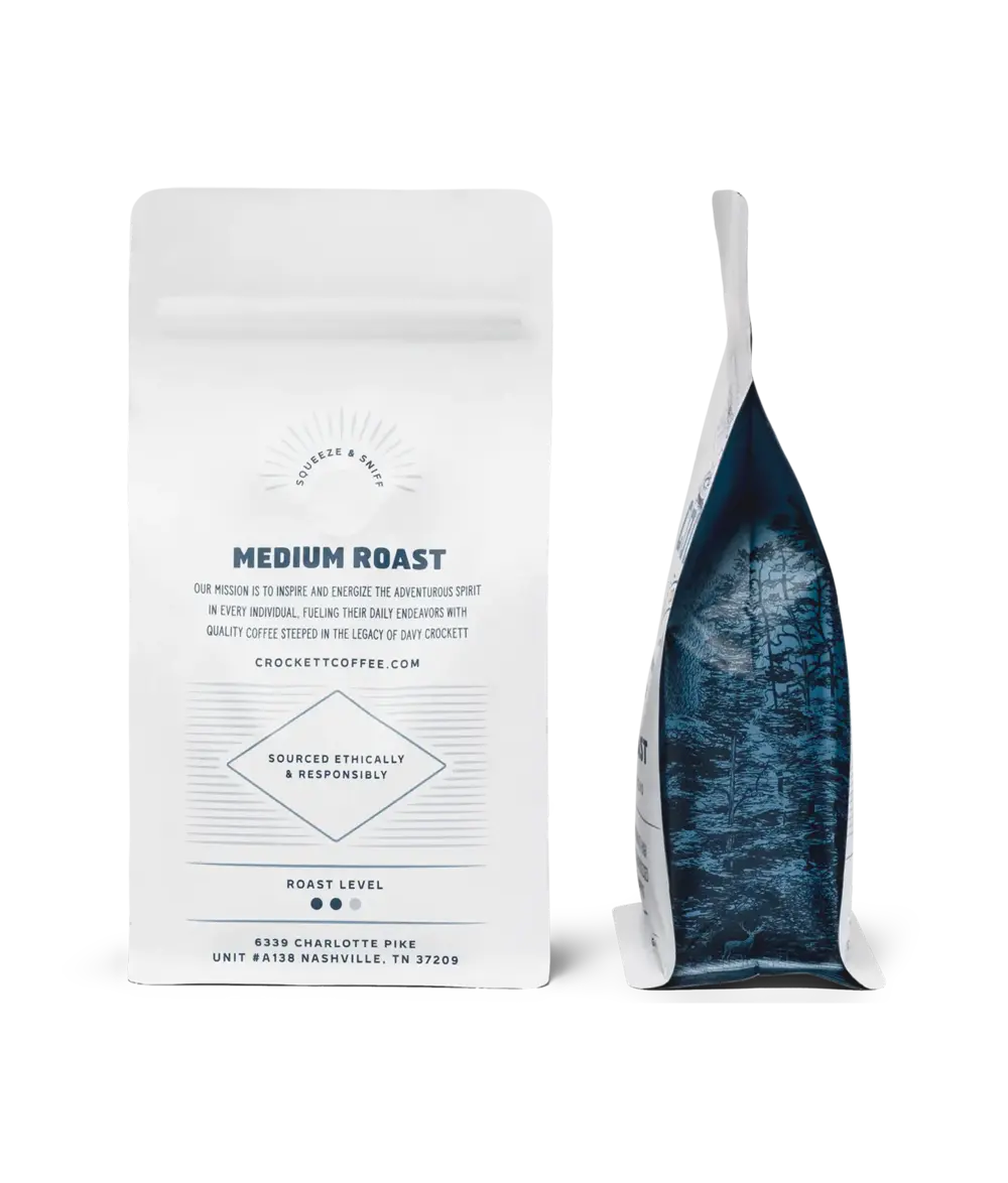 Coffee subscription medium roast bag from Crockett Coffee shown front and side with illustrated forest design.