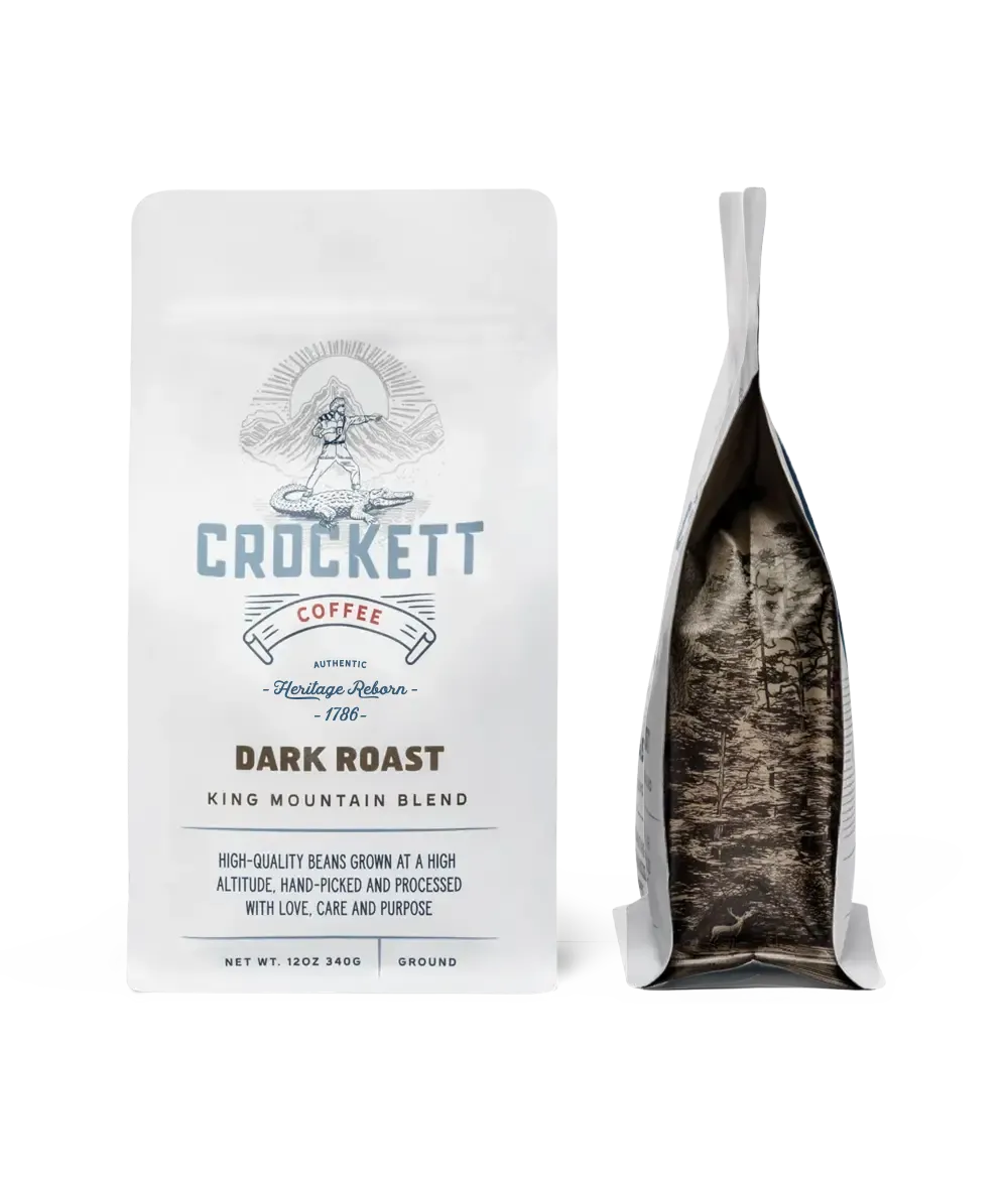 Handcrafted dark roast coffee bag labeled “King Mountain Blend” from Crockett Coffee, featuring premium packaging with a forest-inspired interior design.