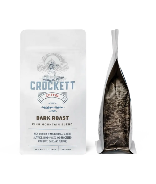 Handcrafted dark roast coffee bag labeled “King Mountain Blend” from Crockett Coffee, featuring premium packaging with a forest-inspired interior design.