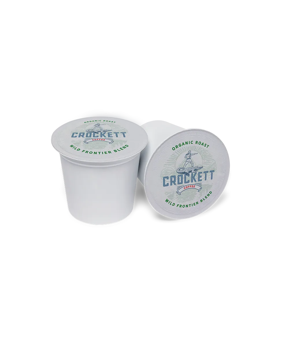 Organic coffee capsules labeled “Wild Frontier Blend” with Crockett Coffee branding, displayed on a plain background.