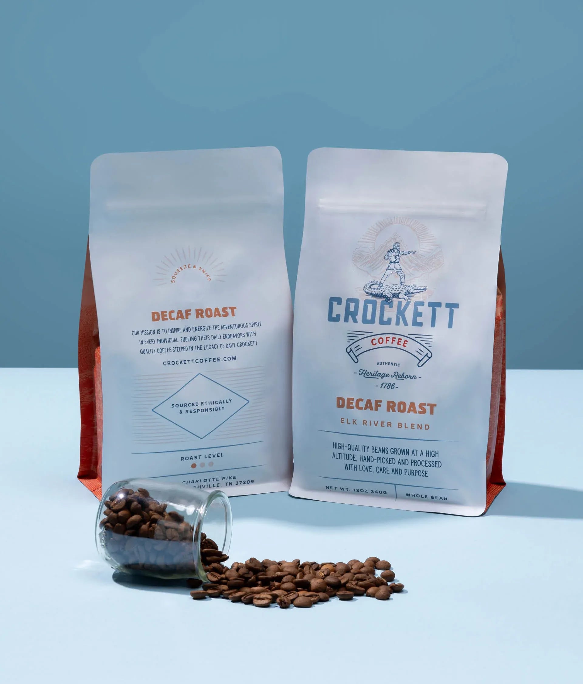 Whole bean decaf in Crockett Coffee’s Elk River Blend, shown in 12 oz bags with a spill of roasted beans and messaging highlighting ethically sourced, high-altitude, hand-picked coffee.