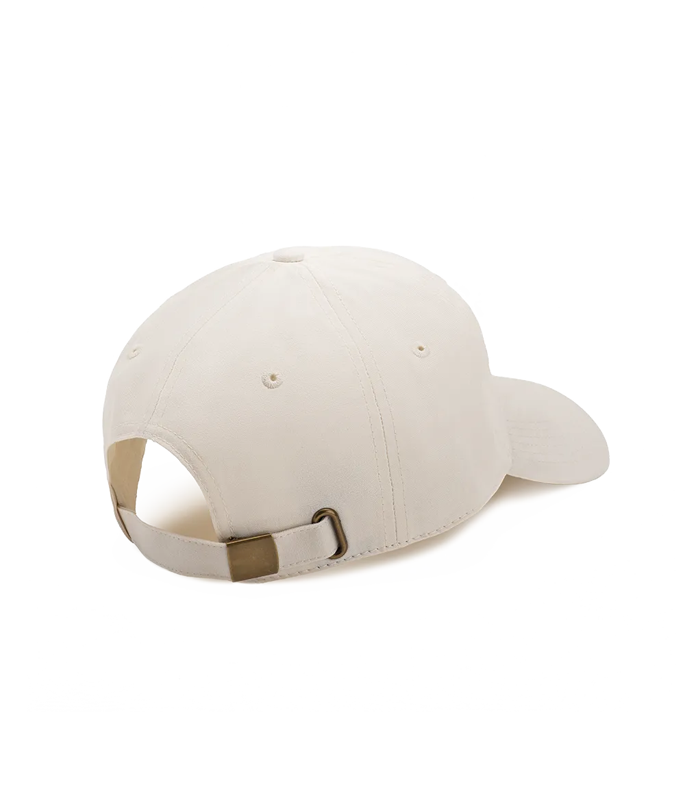 Cotton cap in cream color shown from the back with adjustable strap and brass buckle closure.